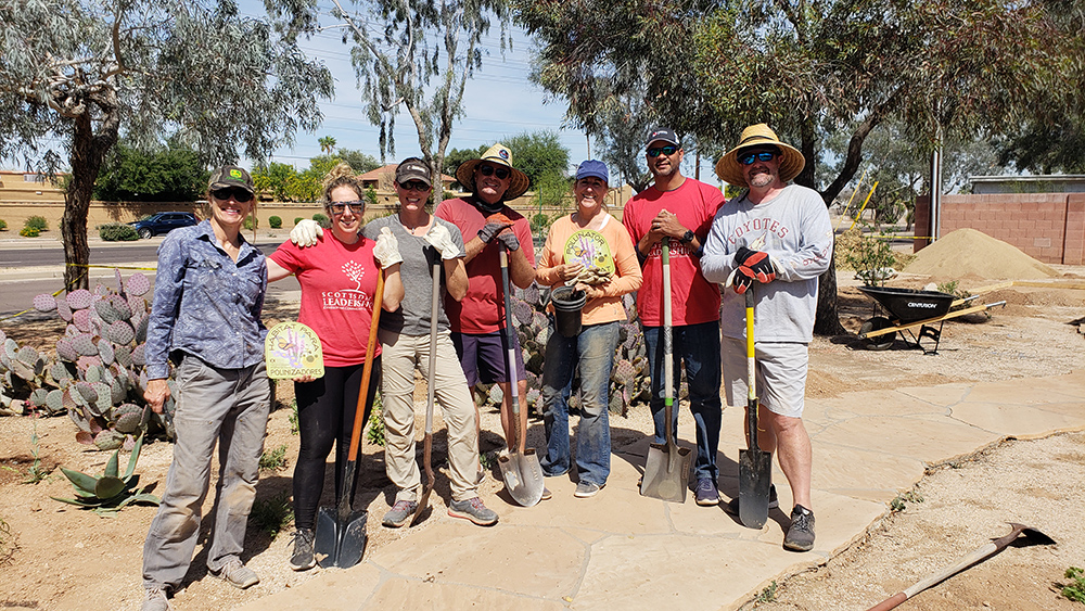 Group of people standing with shovels at the park