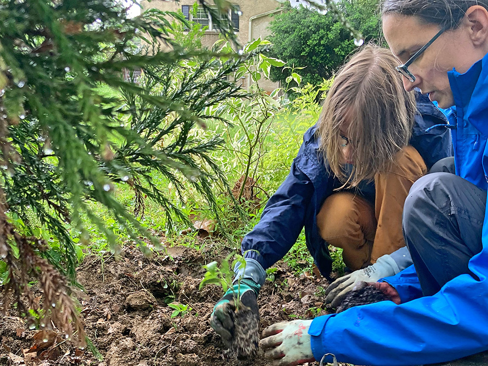 Noah and a family member planting a seedling