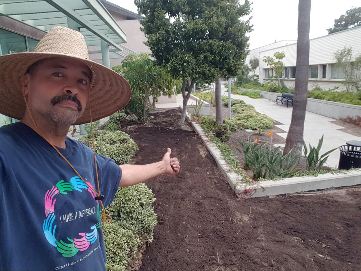 Augustin posing with the prepared beds at the library