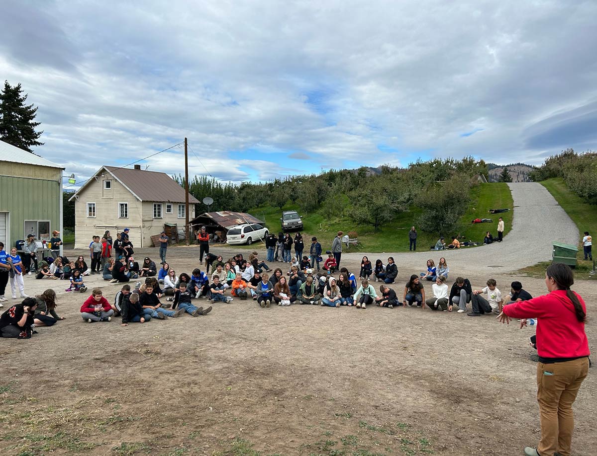 Over a hundred students circle around a speaker, listening