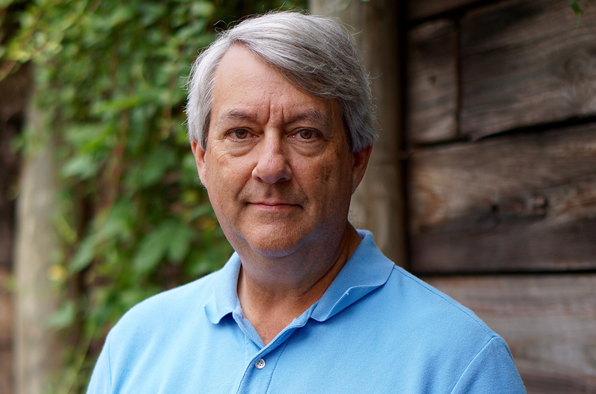 Ted Burk, an older white man with grey hair, smiling gently
