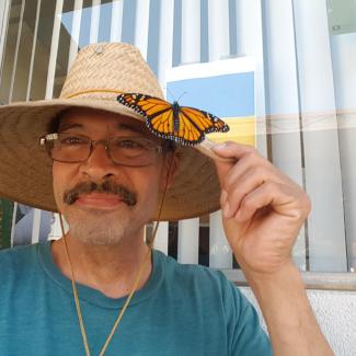 Xerces Society member Augustin Garnier with monarch butterfly on hat